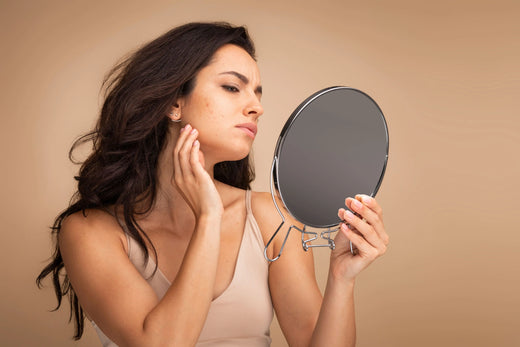 femme qui regarde sa peau dans un miroir Image